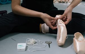 PBT dancer Marisa Grywalski sewing her pointe shoes.